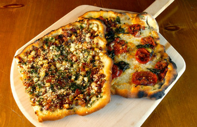 Grilled pizza on wooden pizza peel